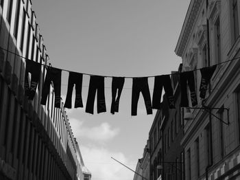 Low angle view of clothes hanging in city against clear sky