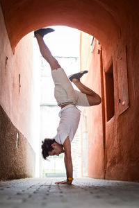 Young man exercising in archway