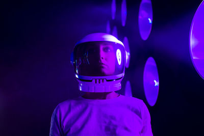 Astronaut wearing space helmet by illuminated lighting