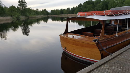 Boat moored in lake against sky