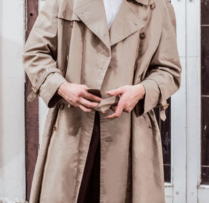 Midsection of man wearing long coat