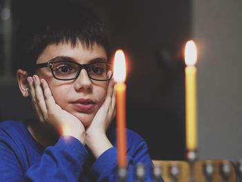 Boy looking at lit candles on hanukkah menorah