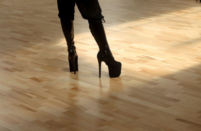 Low section of woman standing on hardwood floor