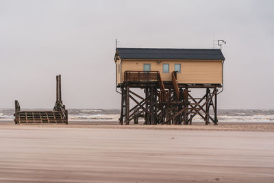 Lifeguard hut on beach against sky