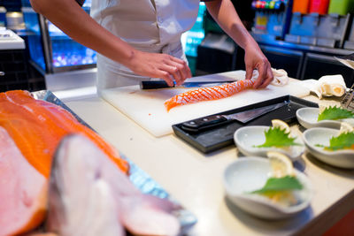 Midsection of man preparing food on cutting board