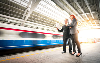 Full length of men standing on railroad station platform