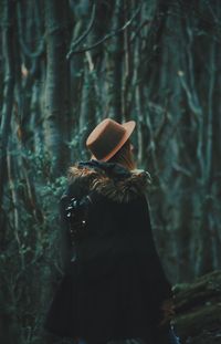 Woman exploring amidst trees in forest