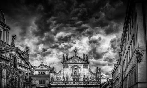 Low angle view of buildings against cloudy sky