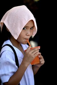 Close-up of girl drinking juice from glass outdoors