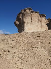 Rock formation on land against clear blue sky