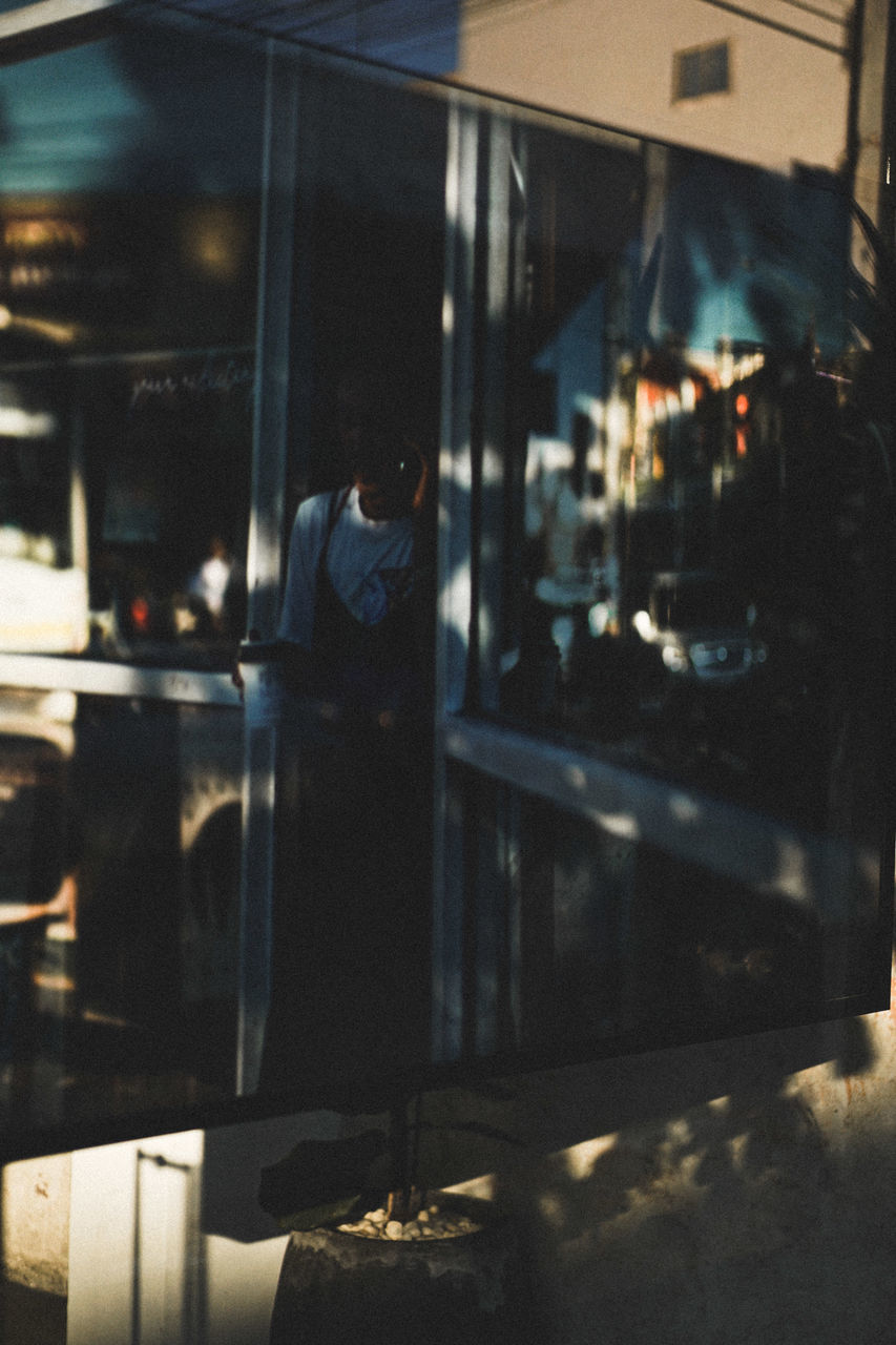 REFLECTION OF MAN IN GLASS WINDOW