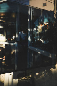 Reflection of man on glass window at restaurant