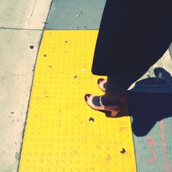 Low section of man walking on road