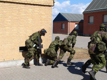 Rear view of soldiers standing against wall