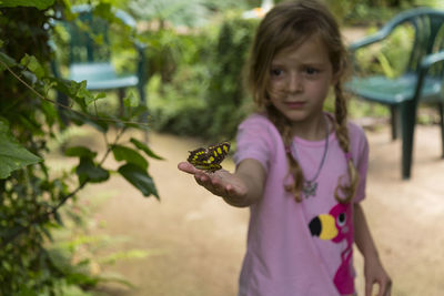 Close-up of girl holding pink flower