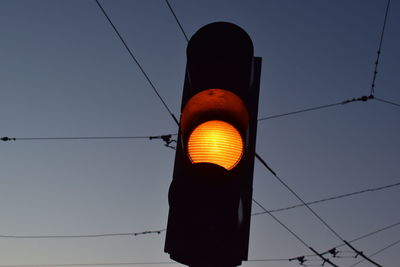 Low angle view of illuminated light against sky at dusk