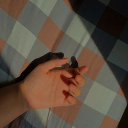 High angle view of person hand on tiled floor