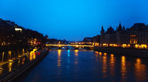 Illuminated bridge over river against sky at night