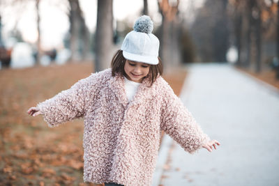 Girl in warm clothing playing at park