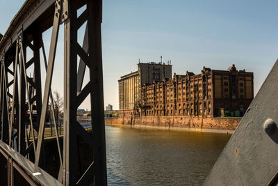 Bridge over river against buildings in city