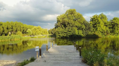 Scenic view of lake by trees against sky