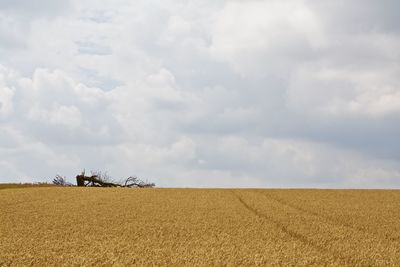 Scenic view of field against cloudy sky