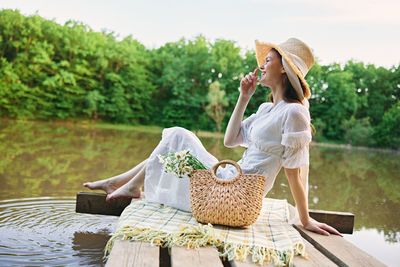 Side view of woman sitting on bench