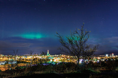 Illuminated cityscape against sky at night
