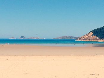 Scenic view of beach against clear blue sky