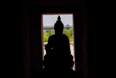 Silhouette statue against building