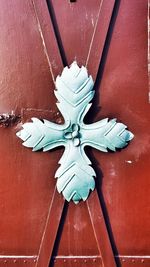 High angle view of cross on wood against wall