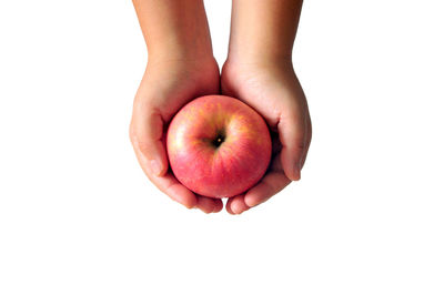 Close-up of hand holding apple against white background