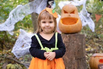 Halloween. cute little girl in pumpkin costume having fun, celebrating halloween outdoor