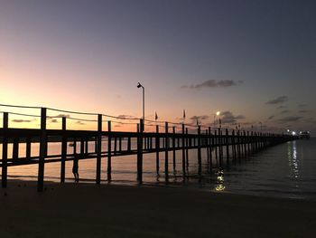 Pier over sea against sky during sunset