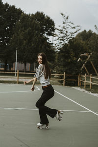 Full length of young woman sitting on field