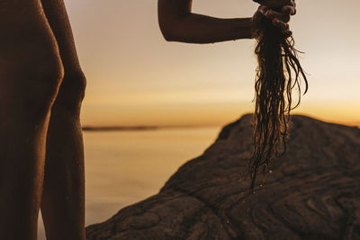 Silhouette of woman drying her hair at sea