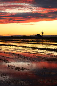 Scenic view of beach against romantic sky at sunset
