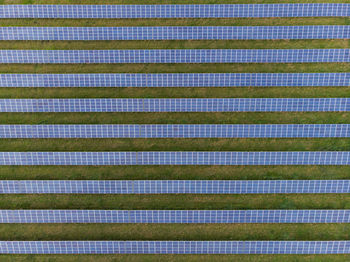 Lines of solar panel cells all linked together reflecting the sunshine.