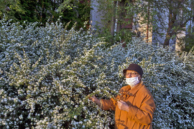 Portrait of smiling woman standing by plants