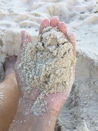 Close-up of hand on sand