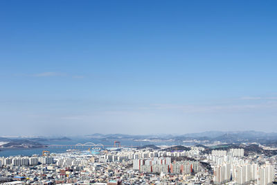 High angle view of townscape by sea against sky