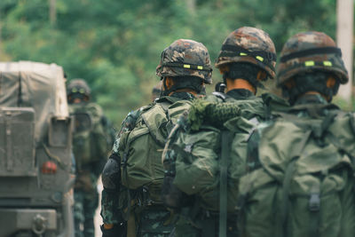 Rear view of soldiers standing on field