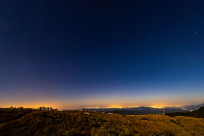 Scenic view of landscape against sky at night