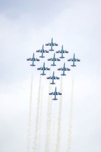 Low angle view of airshow against clear sky