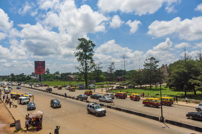 High angle view of vehicles on road against cloudy sky