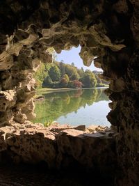 Scenic view of lake seen through cave