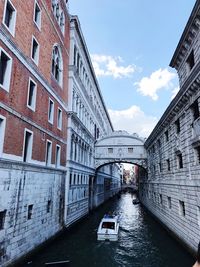 Canal amidst buildings against sky