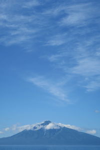 Scenic view of snowcapped mountains against blue sky