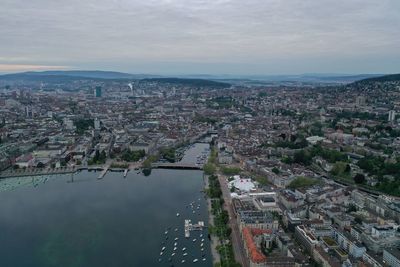 High angle view of cityscape by sea against sky