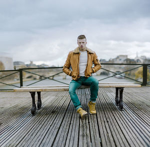 Portrait of young man sitting on skateboard